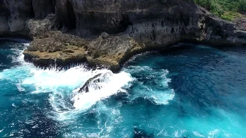 Medium shot of sea waves splashing the base of a cliff Stock Footage 81517522