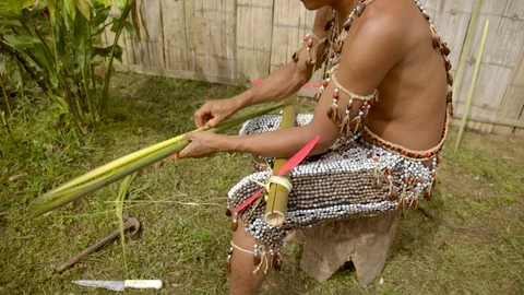 Medium shot showing an indigenous man wearing traditional outfit who is trying Stock Footage 113179959