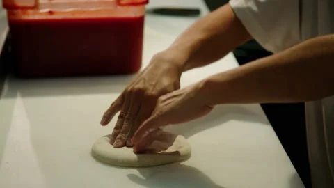 Medium shot, side angle pizza dough being stretched slow motion Stock Footage 229808921