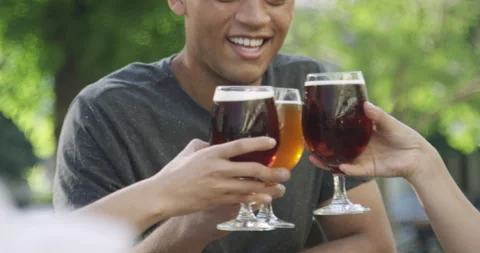 Medium shot side view of group of friends drinking beer and making a toast while Stock Footage 277966840