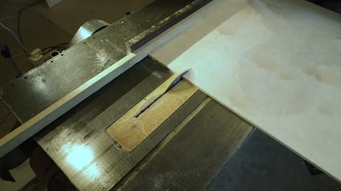 Medium shot side view of mature furniture maker using circular saw to make cuts Stock Footage 107612895