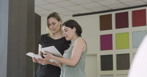 Medium shot side view of two female small business owners looking at color Video stock 277966206