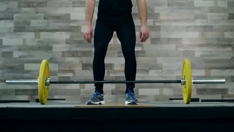 Medium shot slow mo tilt-down tilt-up men exercising and lifting weights female Stockbeeldmateriaal 74311443