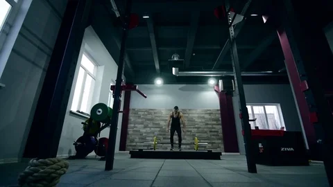 Medium shot slow mo tilt-down tilt-up men and women exercising and lifting Stock Footage 75348332