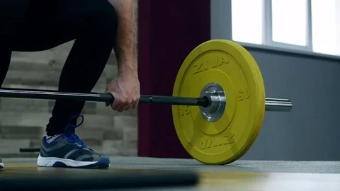 Medium shot slow mo tilt-down tilt-up men exercising and lifting weights female 動画素材 75397434