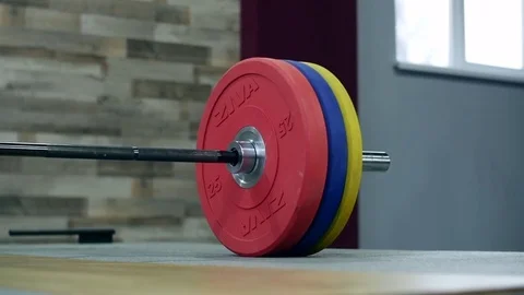 Medium shot slow mo tilt-down tilt-up men exercising and lifting weights female 動画素材 75397485