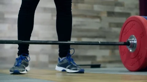 Medium shot slow mo tilt-down tilt-up men exercising and lifting weights female Stock Footage 75397623