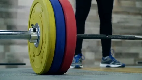 Medium shot slow mo tilt-down tilt-up men exercising and lifting weights female 動画素材 75397731