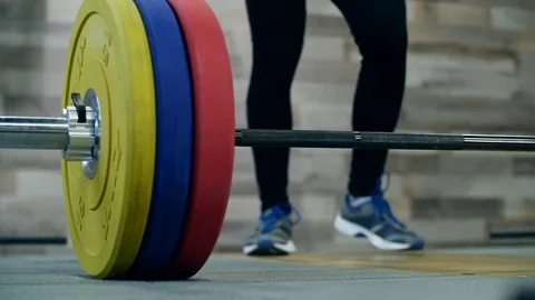 Medium shot slow mo tilt-down tilt-up men exercising and lifting weights female 動画素材 75397790