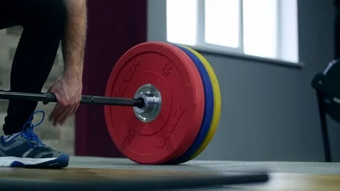 Medium shot slow mo tilt-down tilt-up men exercising and lifting weights female 動画素材 75397877