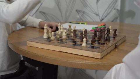 Medium shot smart boy is playing chess with his mom while sitting at a table Stock Footage 259870330