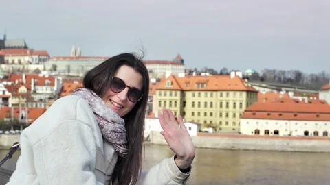 Medium shot smiling elegant female tourist waving hand looking at camera 動画素材 106634723