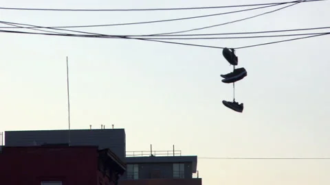 Medium shot of sneakers hanging on wire during sunset in New York City, USA Vídeos de archivo 202903760