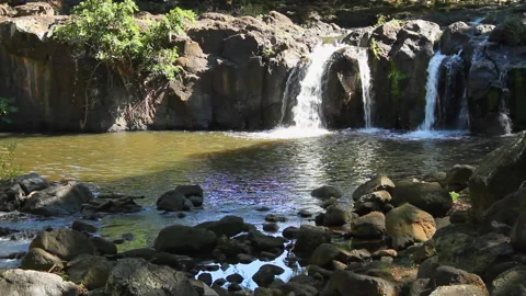 Medium shot, static, small waterfall cascading into a rocky pool Stock Footage 272348064