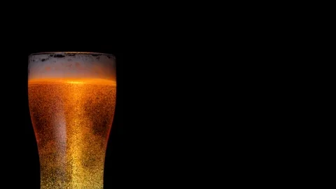 Medium shot stream of fresh cold beer beverage pouring into full big glass Stock Footage 103551010
