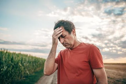 Medium shot of a stressed middle-aged man standing on a rural dirt road by .. Stock Photos