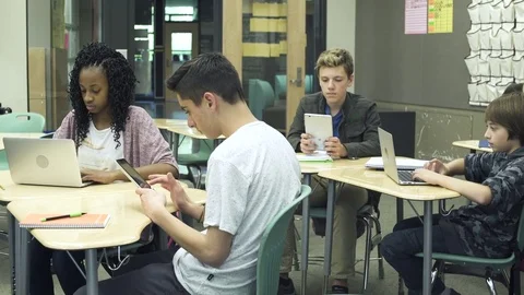 Medium shot of students using tablets and laptops in classroom 動画素材 76230464