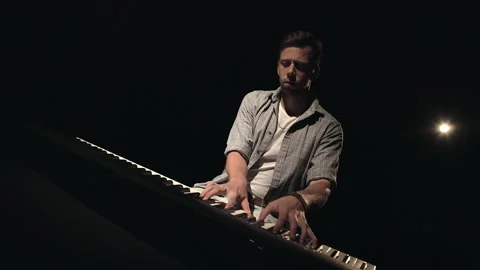 Medium shot of a stylish handsome young man who playing the electronic piano Stock Footage 157952597