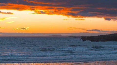 Medium shot of the sun setting on the ocean in a beautiful sunset Stock Footage 124997987