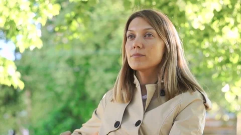 Medium shot of a thoughtful young pretty girl sitting and looking around Stock Footage 77200814