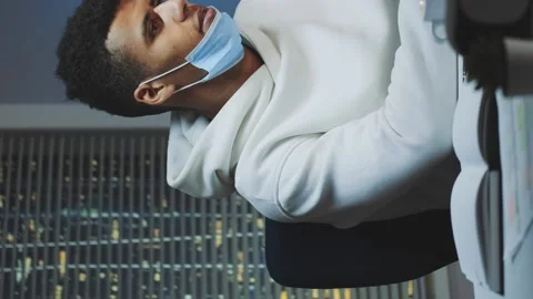 Medium shot of Tired multiethnic man with protective mask working home late at Stock Footage 131532094
