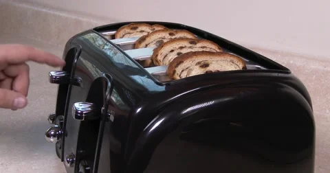 Medium shot of toast in a toaster, going down and popping up, real time in 4K Stock Footage 57627149