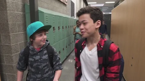 Medium shot of two friends talking on school corridor Stock Footage 73289688