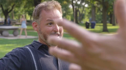 Medium Shot - Two men greet and hug each other at a park - shot on RED Stock Footage 124909616