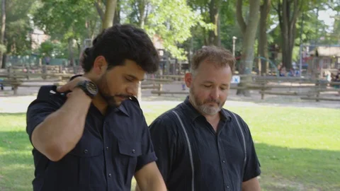 Medium Shot - Two men walk down the street while talking - shot on RED Stock Footage 124716964