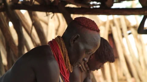 Medium Shot of Two Omo Valley Tribe Members Working In Their Hut Stock Footage 66519729