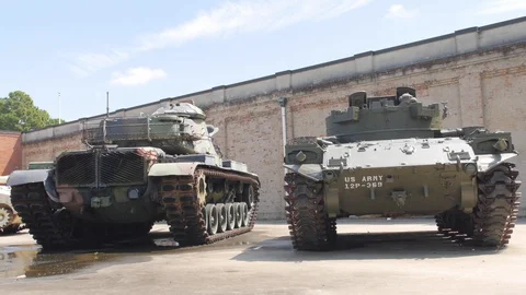 Medium shot of two U.S. Army tanks with another in the background. Stock Footage 129353797