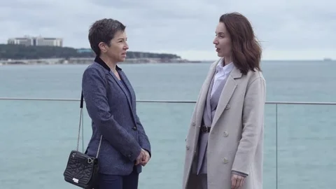 Medium shot two women talking against the backdrop of a seascape 스톡 동영상 150171840
