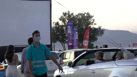 Medium shot valet helping driver park in Drive In cinema Stock Footage 142941106