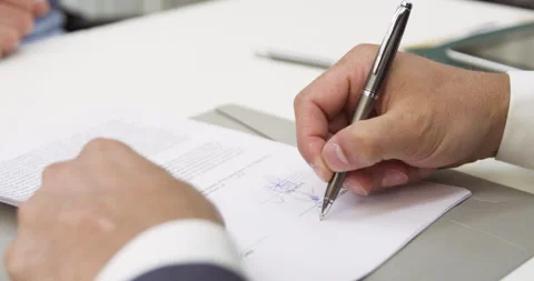 Medium shot view of unidentified person's hands signing a contract Stock Footage 277950402
