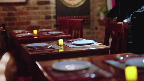 Medium Shot of Waitress Setting Table in Thai Restaurant at Night Handheld Stock Footage 305631628