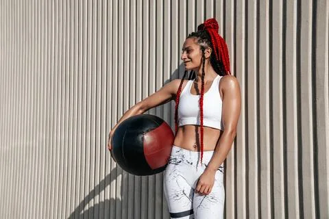 Medium shot on wall background. Athletic woman with med ball. Strength and .. Stock Photos
