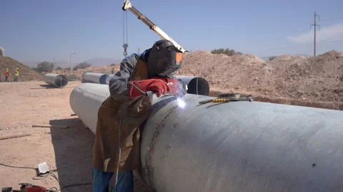 Medium Shot of Welder Joining Large Metal Pipeline with Audio Stock Footage 334941908