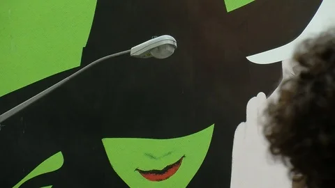 Medium Shot of Wicked play ad on Broadway in New York City with passersby 스톡 동영상 87047912