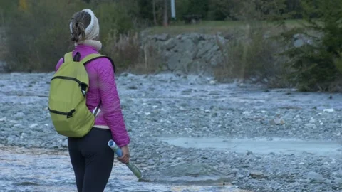 Medium shot woman observes flowing river water. Video stock 166317237
