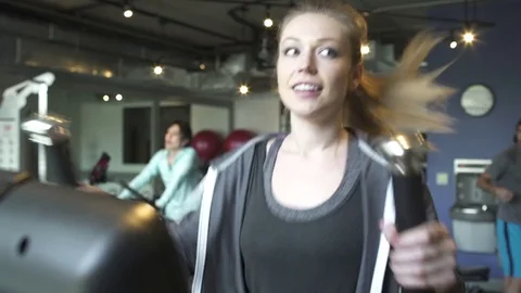 Medium shot of a woman using an elliptical trainer Stock Footage 76539157