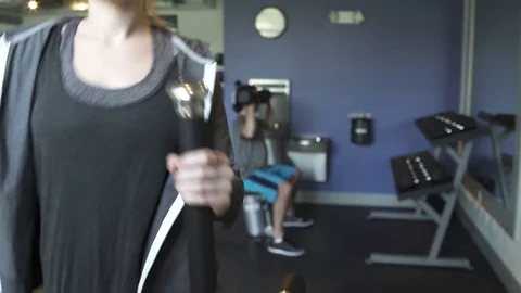 Medium shot of a woman using an elliptical trainer Stock Footage 76539185