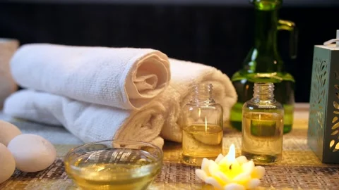 Medium shot of a wooden spa table ready with almond oil and scented wax candl... Stock Footage 264033614