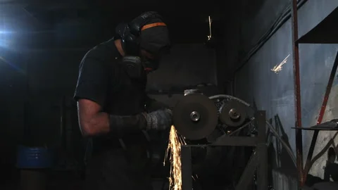 Medium shot of a worker sharpening metal with sparks. Stock Footage 150035592