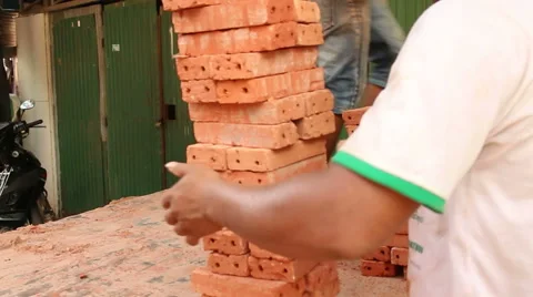 Medium shot of workers completing the unloading and stacking bricks Stock Footage 56604015