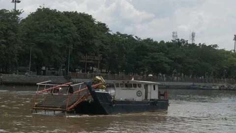 Medium shot, workers in trash skimmer boat cleaning the river Stock Footage 156994494