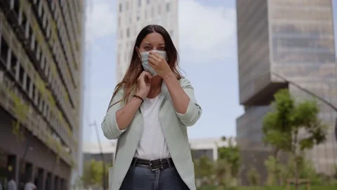 Medium shot of a working woman putting on a mask looking at camera Stock Footage 139650034