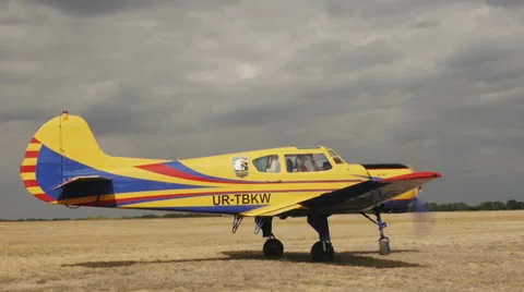 Medium shot Yellow plane Yakovlev Yak-18T awaits clearance to take off. Passing Stock Footage 38393233