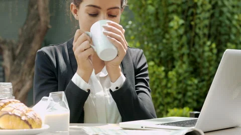 Medium shot of young attractive professional woman having a coffee break while u Stock Footage 199634898