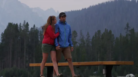 Medium shot of young couple walking on dock / Redfish Lake, Idaho, United States Stock Footage
