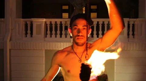 Medium shot of young Fire Dancer makes acrobatics with fire to camera Stock Footage 20461375